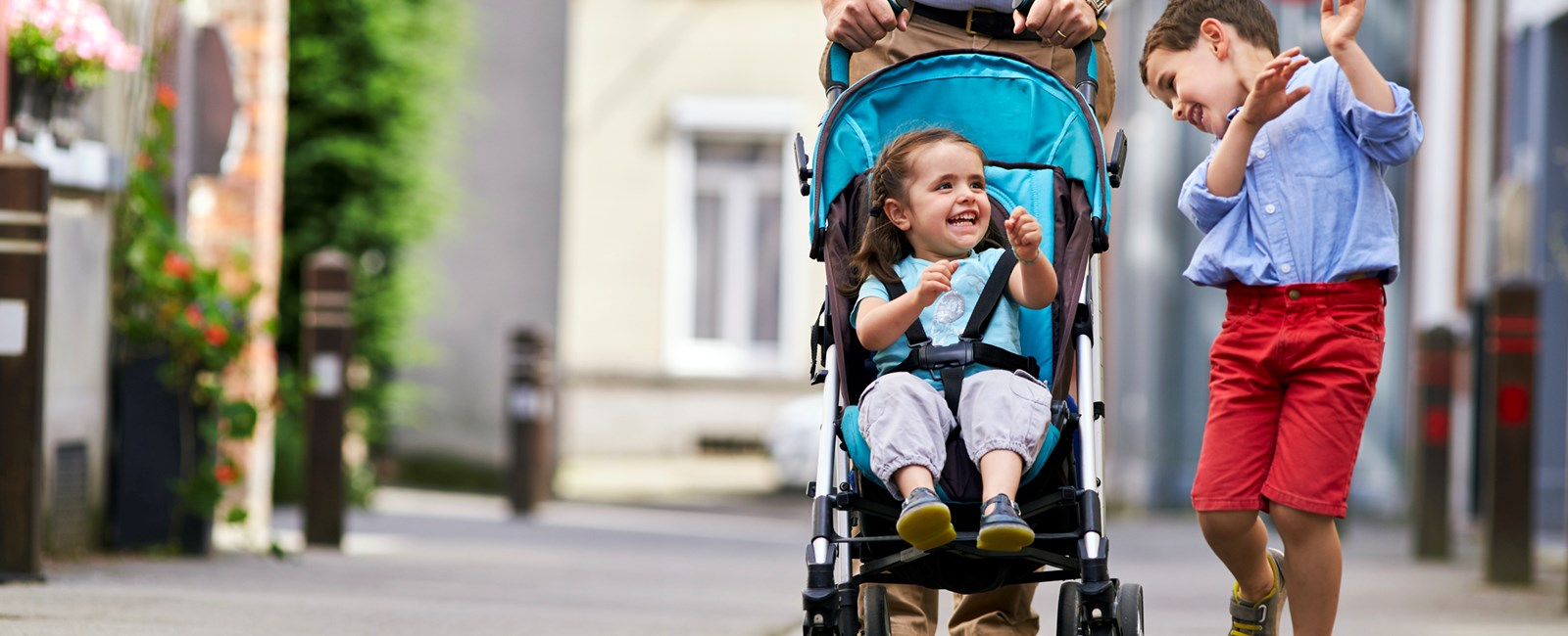 Children playing whilst on walk, one in a pram (Belgium)