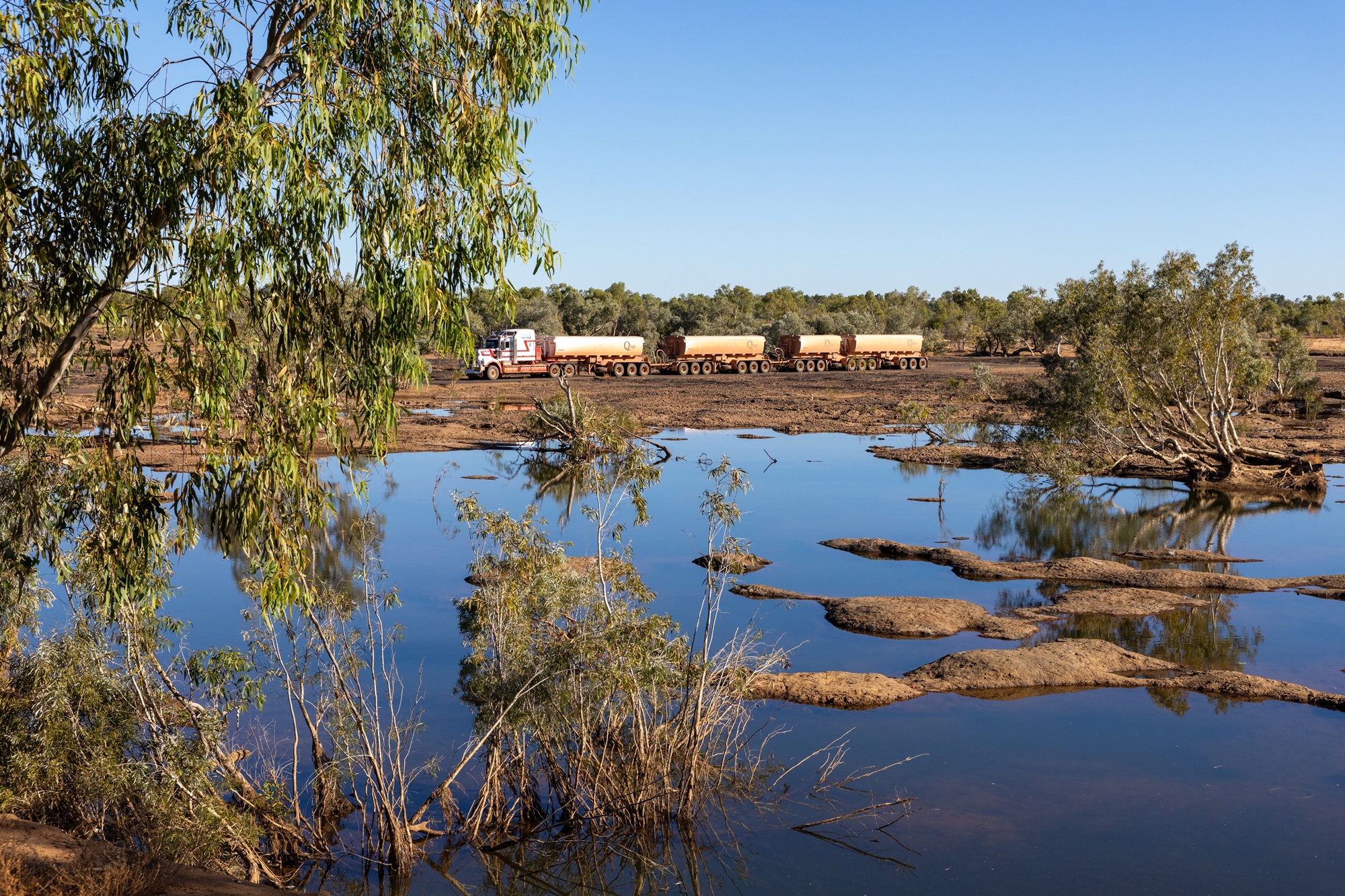 A riverbank with a truck in the background