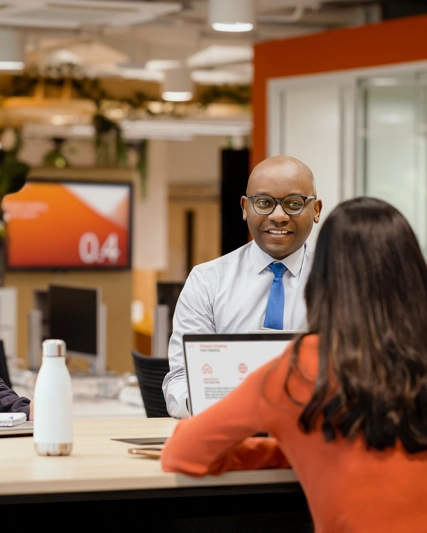 Two men and one woman sitting and conversing in the office